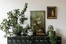 25 a gorgeous black vintage card cabinet with potted plants and vintage artwork will instantly turn your space in a refined vintage one