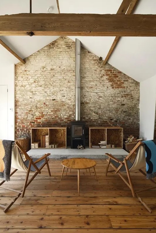 a rustic industrial living room with a rough brick wall and wooden beams that make up a character