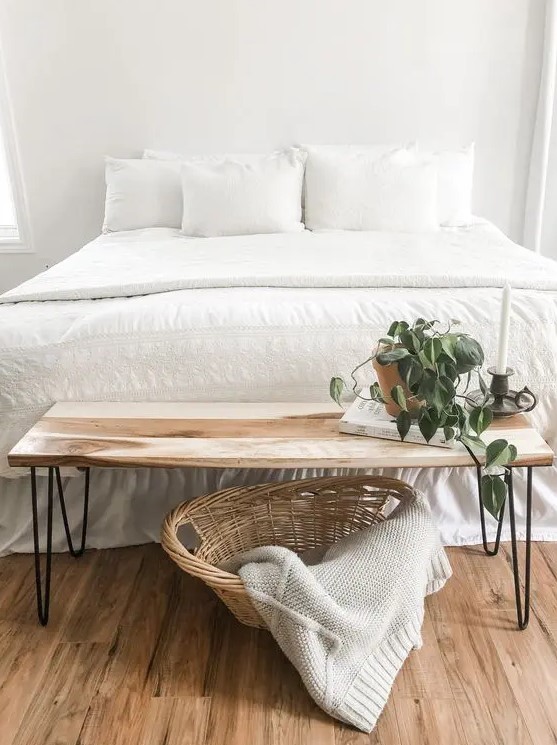 a lovely Scandi bedroom with a white bed and bedding, a simple hairpin leg bench and a basket is a cool space