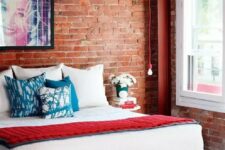 31 a bright contemporary bedroom with a comfy bed, a hanging bulb and an exposed brick statement wall that takes over the whole space