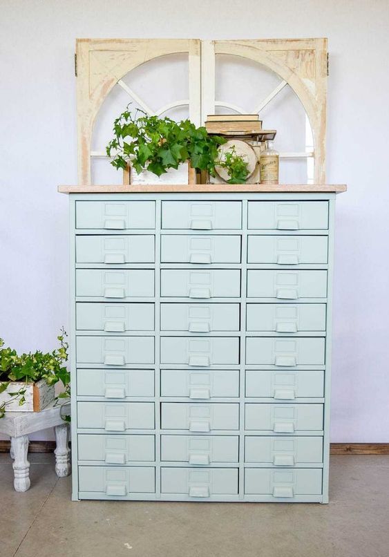 a vintage mint-colored apothecary cabinet with books, bottles, greenery is a delicate and chic idea for a shabby chic space
