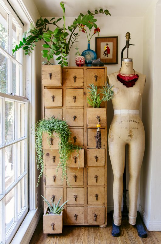 a vintage stained card cabinet as a storage unit and a plant stand is a lovely and cool idea for a vintage-infused space