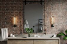 48 a red brick wall contrasts the sleek vanity, wall lamps and copper pipes isntead of a usual mirror frame