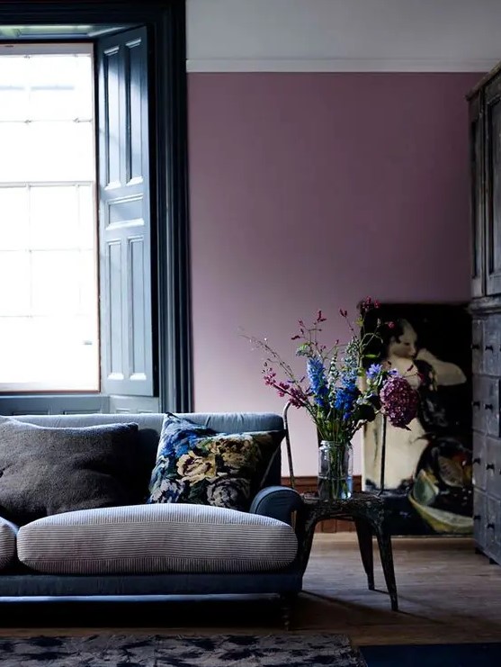 a beautiful living room with a purple accent wall, a navy and grey sofa, a pretty artwork and a vintage sideboard is a gorgeous space