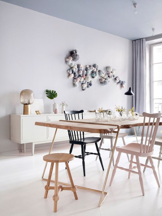 a beautiful pastel dining room with a blue ceiling, grey walls, a white locker, a living edge table and black, white and pastel chairs