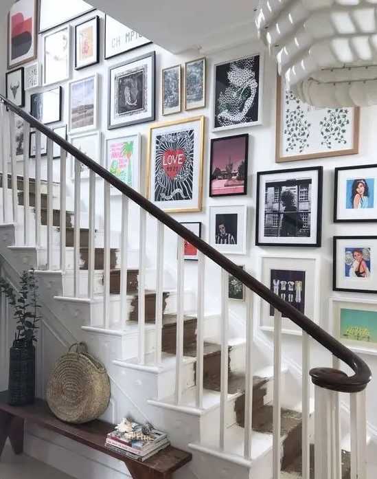 a bright free form gallery wall with colorful artworks and msiamtching frames for an eclectic and fun feel in the space
