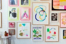 a bright gallery wall with abstract artworks and prints, with neon ligth frames and usual ones for a funky look