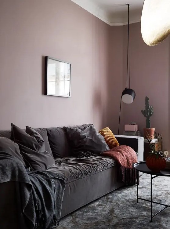 a chic mauve living room with black furniture for more drama, potted plants and pendant lamps looks wow