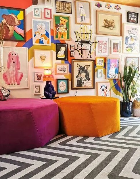 a colorful and bold gallery wall with mismatching frames and super bold artworks in various styles placed on a wall with color block
