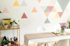 a colorful geometric accent wall done with bright triangles is a creative idea for a modern dining room