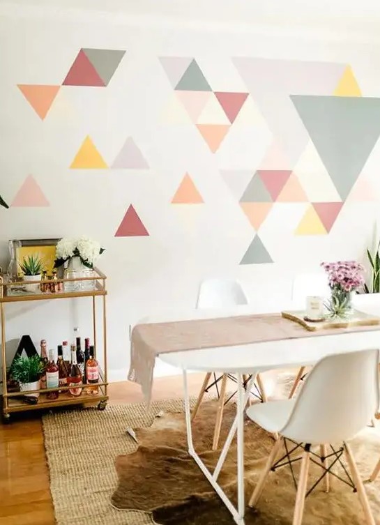 a colorful geometric accent wall done with bright triangles is a creative idea for a modern dining room