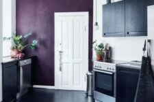 a contrasting black and white kitchen with a deep purple accent wall that adds color and interest to the space and makes it wow