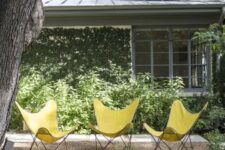a cool garden nook under the tree, with lots of greenery around and yellow butterfly chairs is a very vivacious space