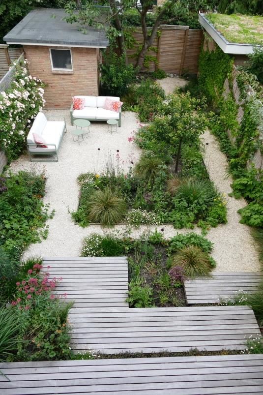 a cool garden space with greenery and blooms, with white and green garden furniture is a lovely space to be in