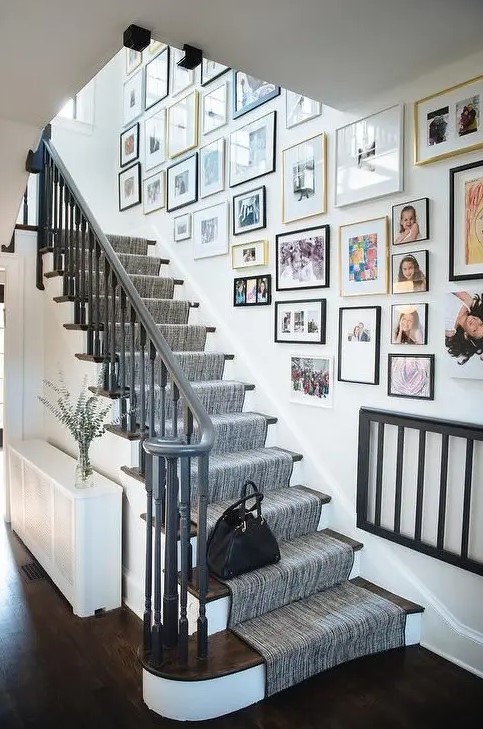 a free form gallery wall with mismatching frames and bold and black and white artworks and family pics is a cool idea