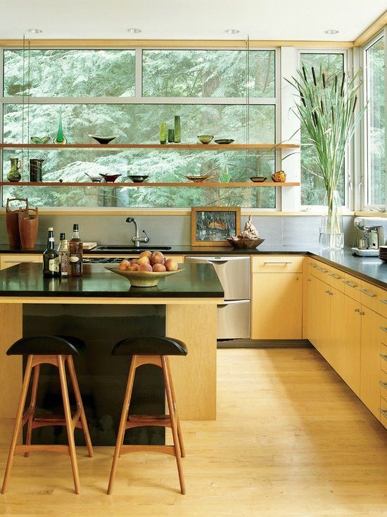 a light-stained modern kitchen with suspended shelves instead of upper cabinets and a large contrasting kitchen island