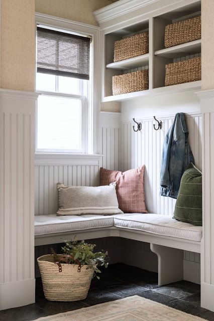 a little country mudroom with a double-hung window, an open box shelf, a corner bench and paneling on the walls