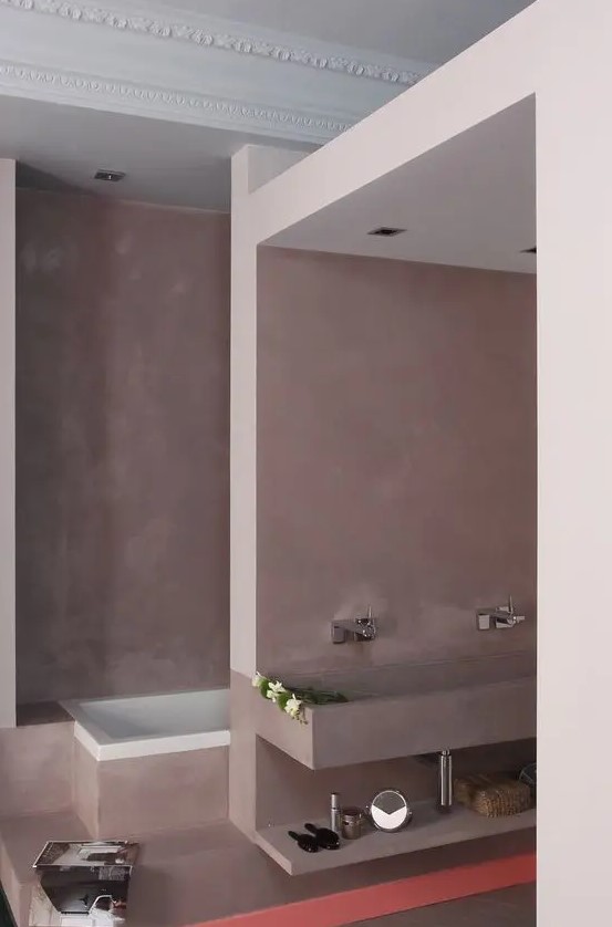 a mauve bathroom with a separated sink and bathtub space and refined decor in Parisian style