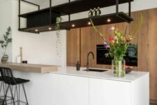 a minimalist kitchen with a large stained storage unit, a sleek white kitchen island, a black suspended shelf and black stools