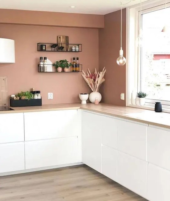 a minimalist mauve kitchen with only lower white cabinets, pendant bulbs, open shelves and white lamps
