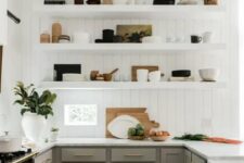 a modern English country kitchen with white planked walls, grey shaker style cabinets, open shelves, gold touches and potted plants