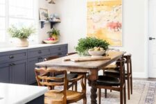 a modern farmhouse kitchen with graphite grey cabinets, a vintage dark-stained table and an antique chair, stylish modern chairs