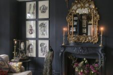 a moody Victorian living room with black walls, a black French fireplace, a grey sofa and a vintage chandelier, a gallery wall