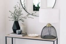 a round mirror in a modern grey frame is a chic and simple idea for a contemporary entryway