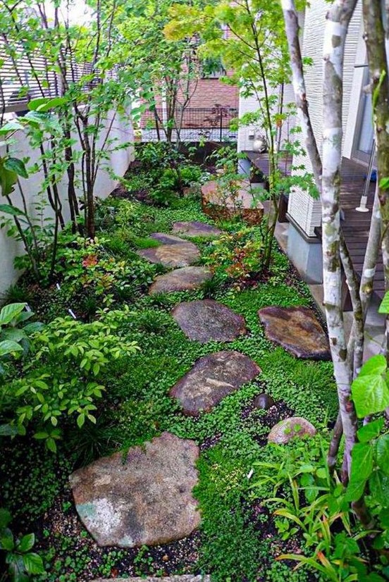 a small Japanese inspired garden with rocks as pavements, greenery, shrubs and a couple of trees is very peaceful