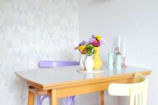 a cute small dining room with a geometric accent wall