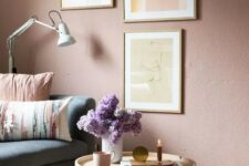 a soothing living room with a mauve accent wall, a neutral and pastel gallery wall and accessories plus a lovely wooden table