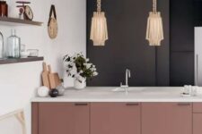 a sophisticated kitchen with a black wall, mauve cabinetry with white coutnertops, beautiful lamps on chain