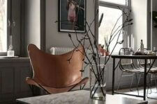 a tan leather butterfly chair by the window becomes a space divider and add texture and interest to the space