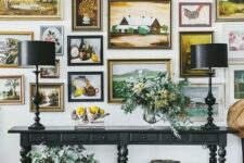a very chic gallery wall with gilded frames and various types of paintings will blow your mind away