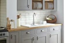 a vintage grey kitchen is softened with wooden countertops and a subway tile backsplash makes it more eye-catchy