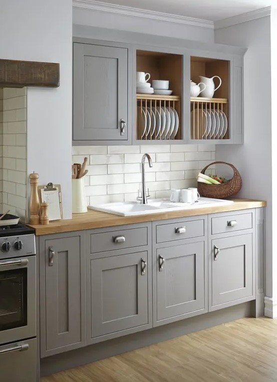 a vintage grey kitchen is softened with wooden countertops and a subway tile backsplash makes it more eye-catchy