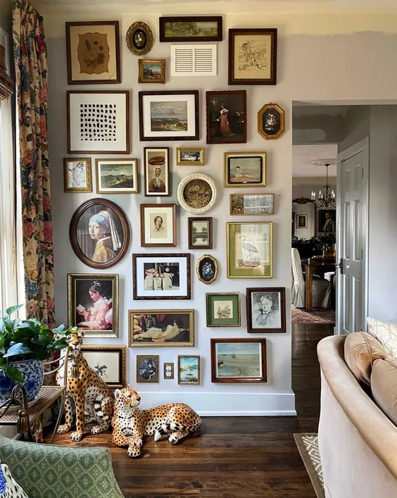 a vintage space with a floor to ceiling gallery wall with various frames and mostly paintings is a very cool and chic idea