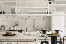 a white kitchen with modern cabinets and a shabby chic kitchen island, suspended shelves, black metal chairs