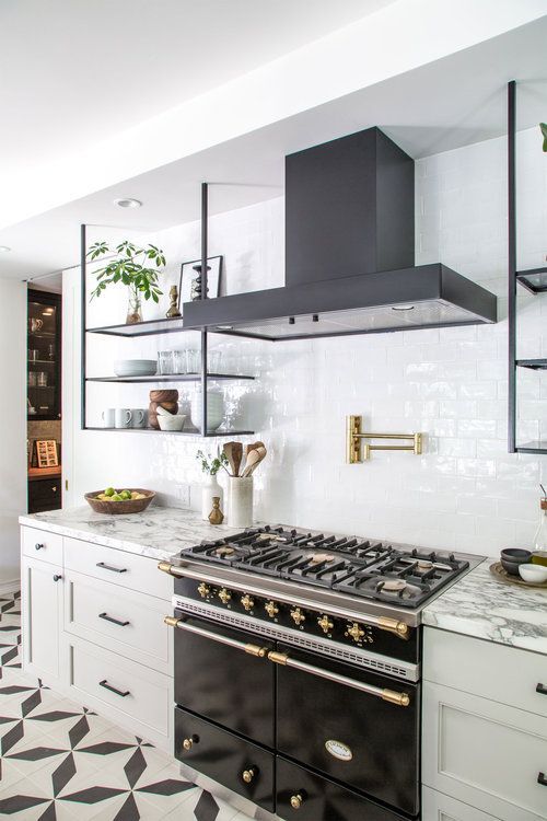 an elegant black and white kitchen with shaker cabinets, black appliances and black suspended shelves instead of upper cabinets