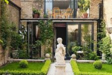 an unusual townhouse garden inspired by classics, with manicured lawns lined up with greenery, mosaic tiles and a large statue in the center