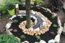 02 a creative swirl garden bed surrounding the tree, with various types of rocks and pebbles is a very cool solution