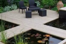 03 a modern garden with green lawn and some blooms, a wooden deck with black outdoor furniture, a couple of ponds