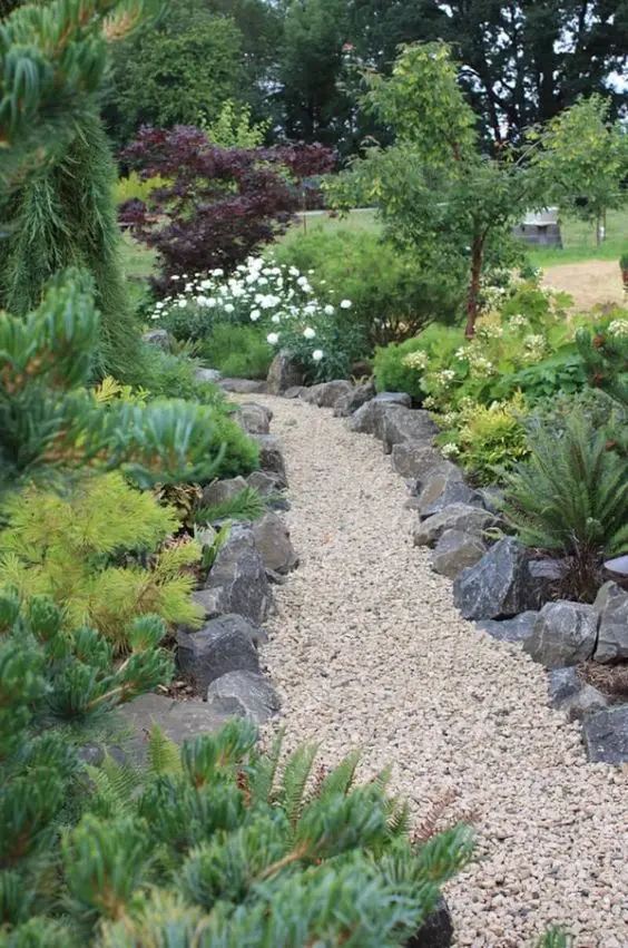 beautiful gravel garden paths lined up with large rocks are amazing to style a garden in a very natural way, it looks chic