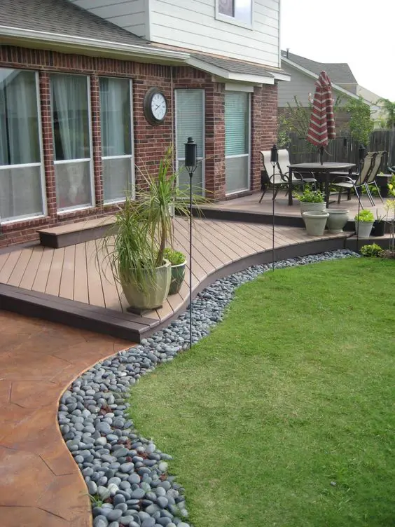 pebbles used to line up a green lawn are a cool idea for any modern garden, they look cool and fresh