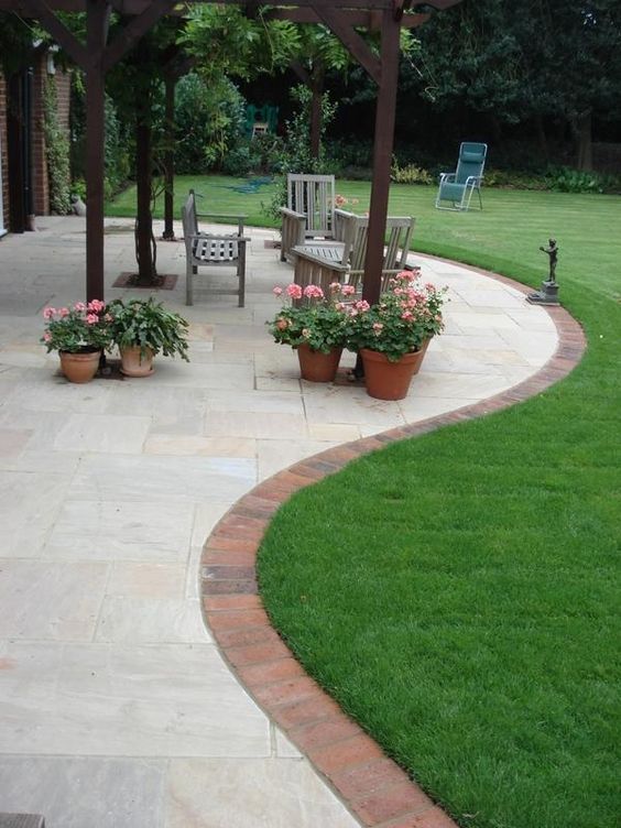 a green lawn, a stone patio and brick edging are a lovely combo for a modern garden, they look chic together