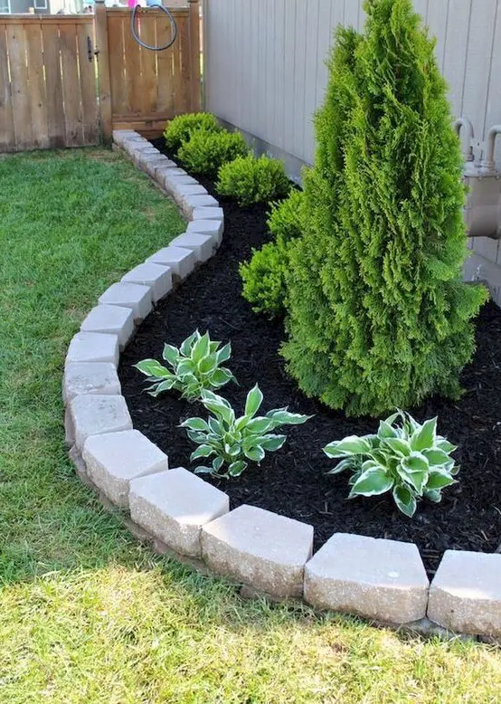 simple stone garden edging to highlight the raised garden bed and separate it from the lawn