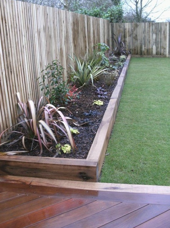 stained wood garden bed edging and matching pathways for a relaxed boho feel in your garden