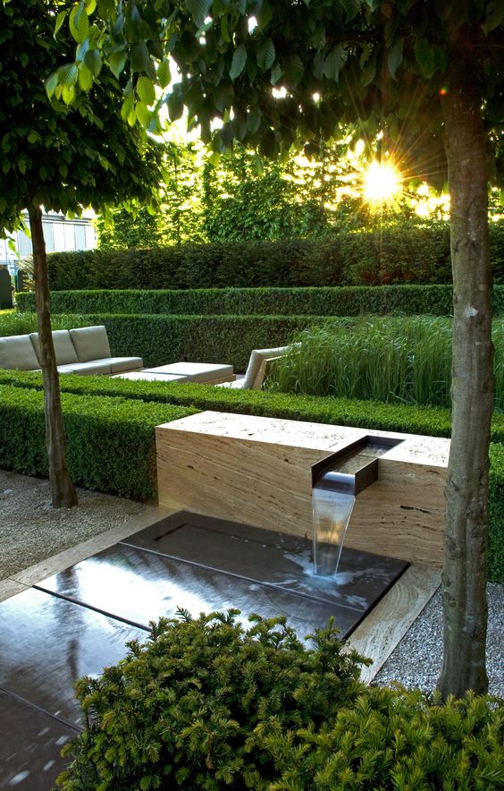 a minimalist water feature - a waterfall on a slab of stone, with greenery around, is a stylish idea for any contemporary or minimalist space
