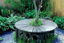 30 an elegant carved stained bench around the tree, with pebbles and blooms around is a lovely sitting spot for your garden