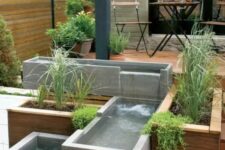 33 a modern outdoor space clad with a wooden deck, with a modern waterfall of concrete boxes and greenery is a cool and edgy nook